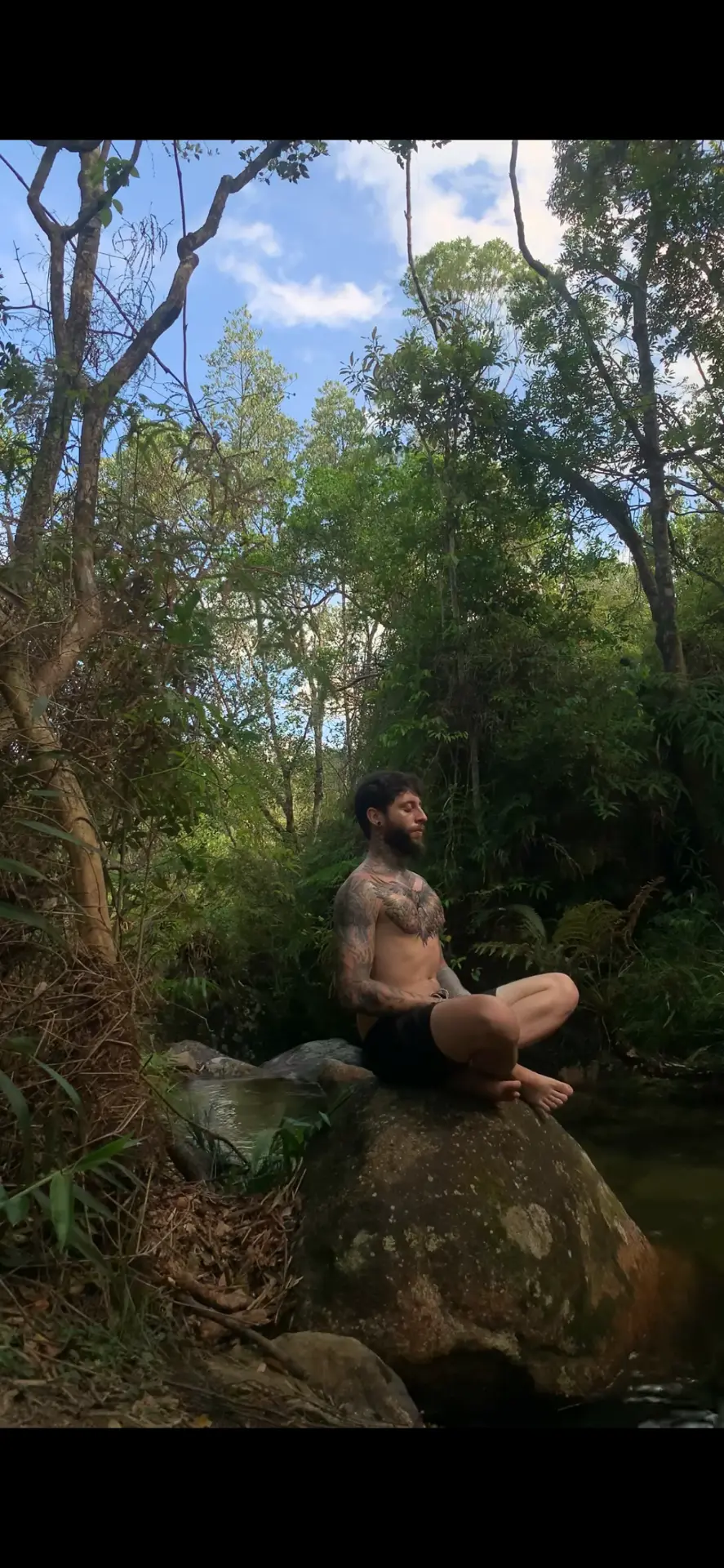 Criador da jornada em meditação sobre uma rocha na natureza